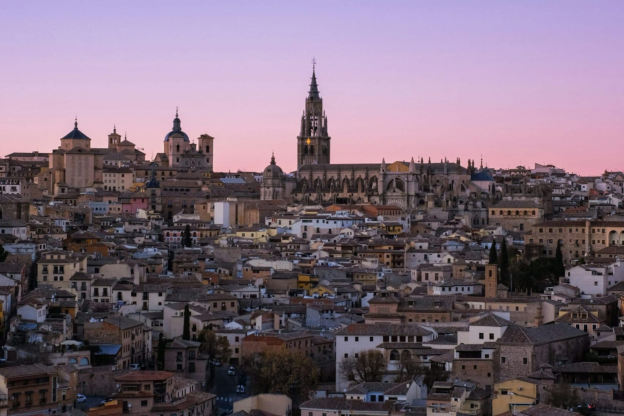 The old town of Toledo at dusk, with the cathedral rising above the roofs.