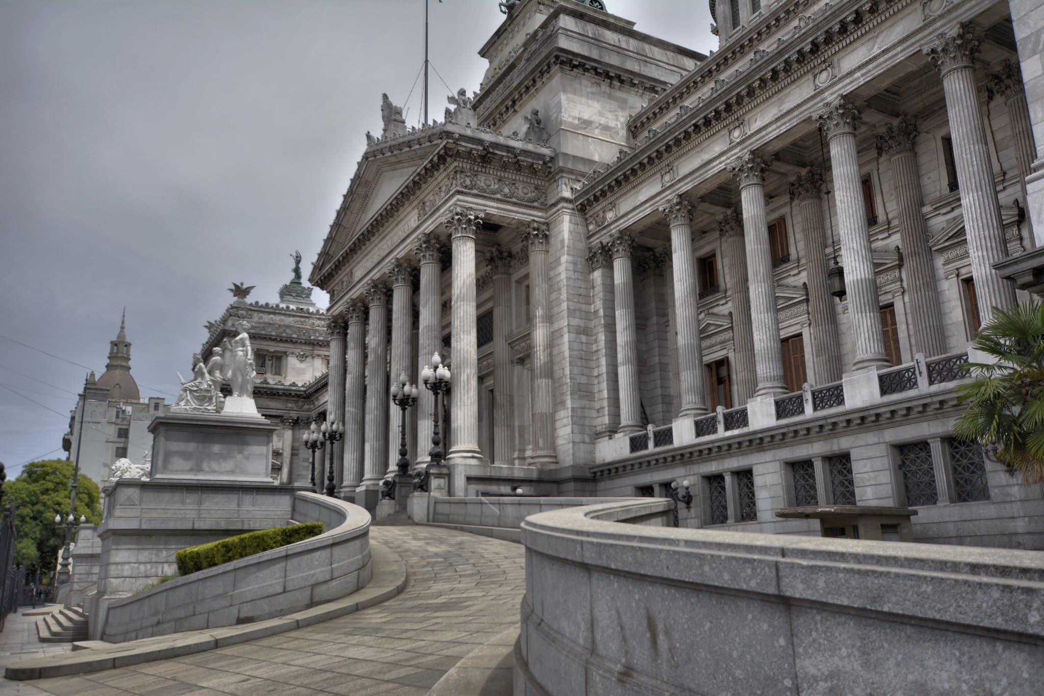 Het Congreso de la Nación in Buenos Aires: de zuilengalerij, de gebogen trap en de koepel van het parlementsgebouw onder een grijze lucht.